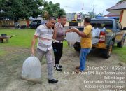 Polsek Tanah Jawa Dukung Swasembada Pangan, Tabur Benih Ikan di Kolam Miliknya